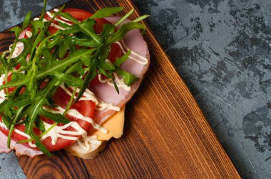 Jambonlu, balyklı, roka peynirli, domatesli ve mayonezli iştah açıcı sandviç.