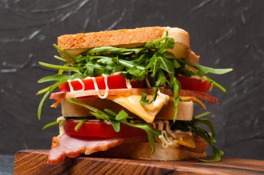 Jambonlu ya da balyklı, roka, peynirli, domatesli ve mayonezli büyük, lezzetli bir sandviç.