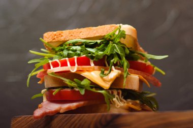 Jambonlu ya da balyklı, roka, peynirli, domatesli ve mayonezli büyük, lezzetli bir sandviç.