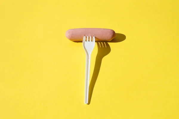 Salsiccia Forchetta Plastica Bianca Sfondo Giallo Brillante Con Luce Dura — Foto Stock
