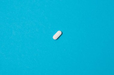 Mavi arkaplan üzerine beyaz hap, izole, metin için yer ile.