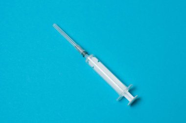 Mavi arka planda tıbbi şırınga izole edildi