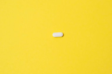 Sarı zemin üzerinde beyaz hap, izole, metin için yer ile