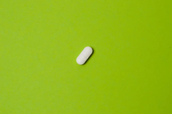 Une Pilule Blanche Sur Fond Vert — Photo