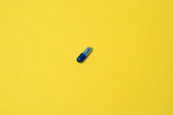 Niebieska Tabletka Żółtym Tle Izolat Miejscem Tekst — Zdjęcie stockowe