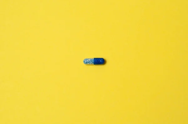 Niebieska Tabletka Żółtym Tle Izolat Miejscem Tekst — Zdjęcie stockowe