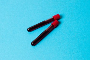 Mavi arka planda kan izole edilmiş iki test tüpü. Tıp konsepti, virüslerle ve bakterilerle mücadele, hastalıklar.