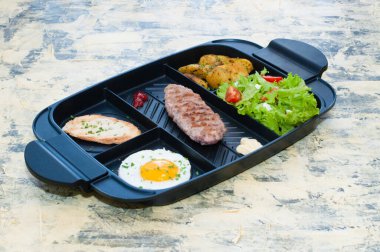 Kahvaltı, kızarmış biftek ya da pirzola, domatesli ve yeşil sebzeli salata, kızarmış ekmek, patates, yumurta manzaralı, açık arkaplan. Sağlıklı beslenme, diyet, menü, iyi beslenme.