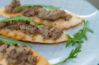 Hamur ve roka soslu kızarmış ekmek. Kutlama aperatifi, yeni yılın İtalyan yemeği. Yandan ve üstten yakın çekim