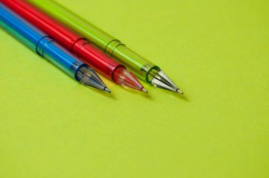 Tasarım için yeşil kağıda farklı renkte jel kalemler.