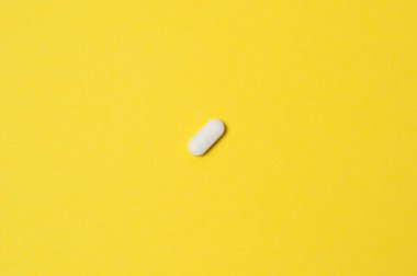 Sarı zemin üzerinde beyaz hap, izole, metin için yer ile