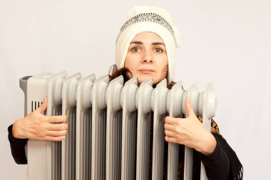 Bir elektrikli ısıtıcı tutan genç kadın