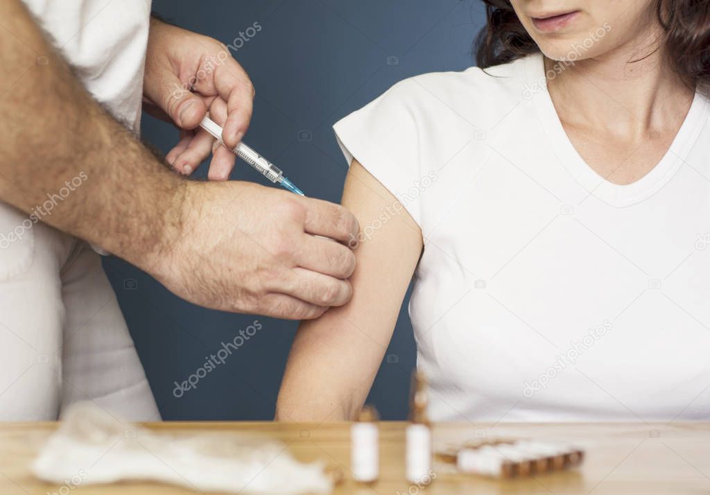 Doctor vaccinating a woman against flu