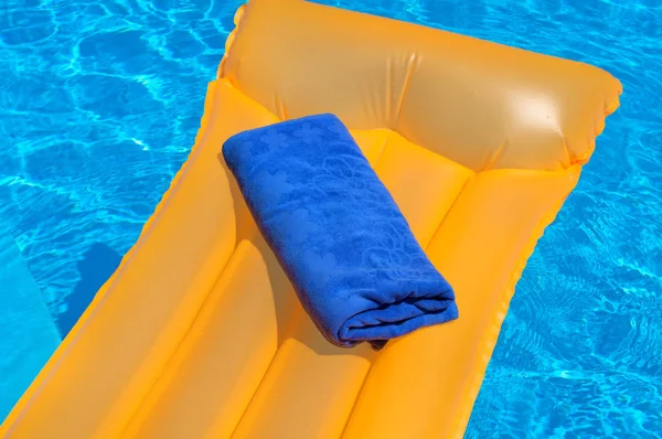 Μπλε πετσέτα σε ένα πορτοκαλί φουσκωτό στρώμα — Φωτογραφία Αρχείου