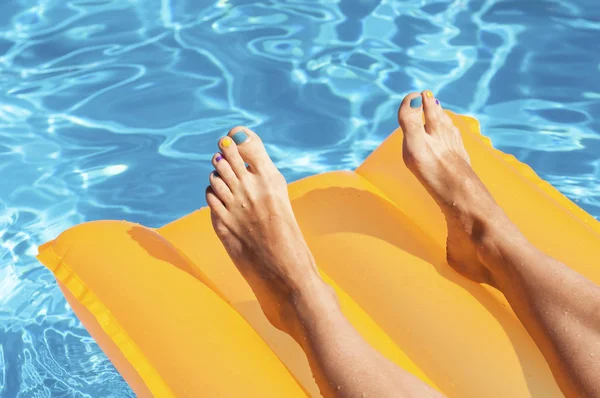 Mujeres piernas en un colchón amarillo — Foto de Stock