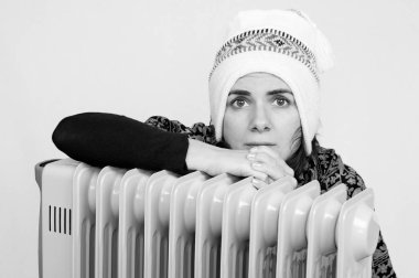 Woman freezing near a heater clipart