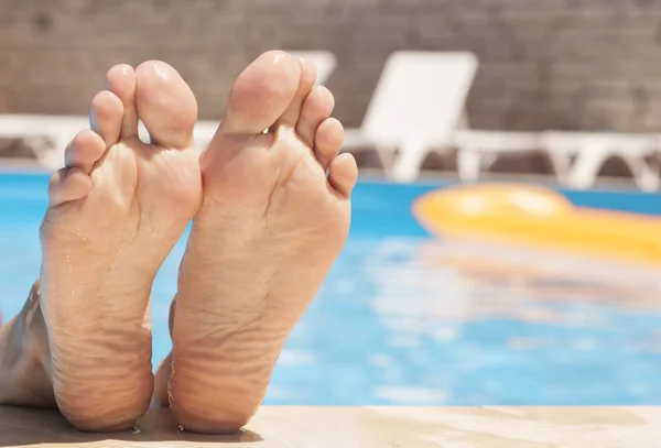 Frauenfüße in der Nähe des Pools — Stockfoto