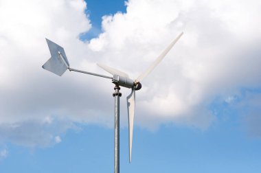 Rüzgar enerjisi türbini mavi, bulutlu gökyüzü karşı