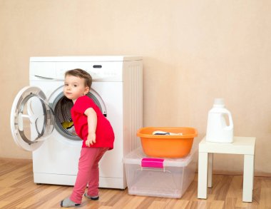 Çamaşırları alır bir kız çamaşır makinesi dışarı yıkanmış