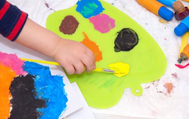 Elinde fırça tutan küçük bir çocuğun eli