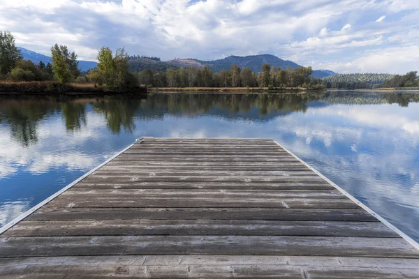 Trä docka genom lugn flod. — Stockfoto