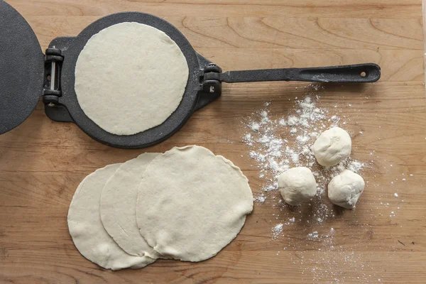 Huisgemaakte bloem tortilla's en een pers. — Stockfoto