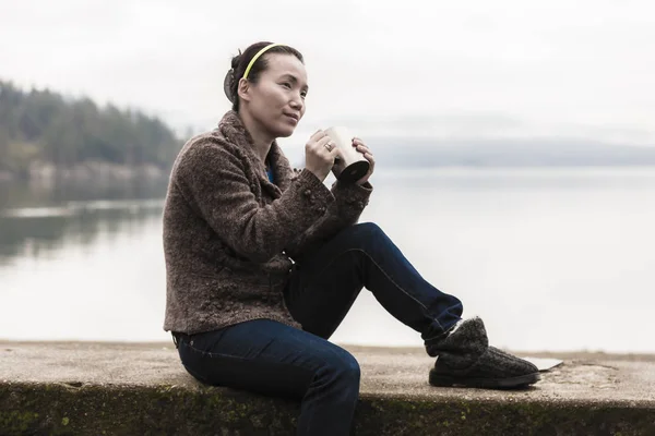 Жінка з кавою біля озера . — стокове фото