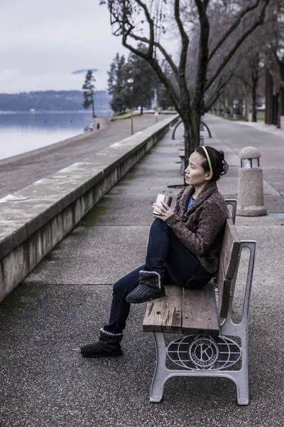 Sitzend auf Parkbank mit ihrem Kaffee. — Stockfoto