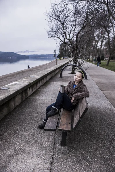 Kvinna avkopplande på parkbänk. — Stockfoto