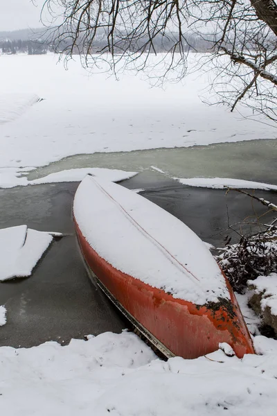 Pokryte śniegiem canoe nad jeziorem. — Zdjęcie stockowe