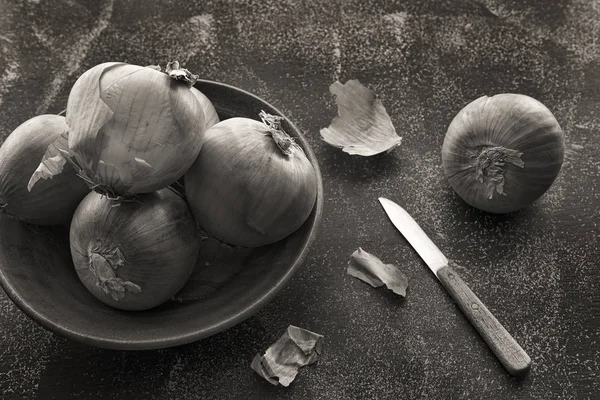 S / w ganze Zwiebeln und ein Messer. — Stockfoto