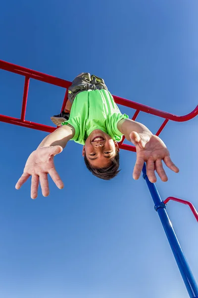 Boy hangs upside down while playing. — Stock Photo, Image