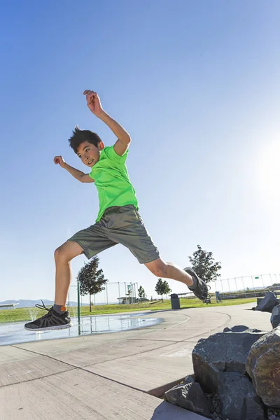 Boy leaping off a rock. — Stock Photo, Image