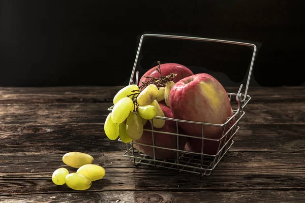 Manzanas y uvas en una cesta . —  Fotos de Stock