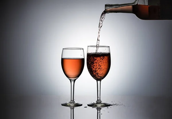 Verser du vin de rose dans un verre . — Photo