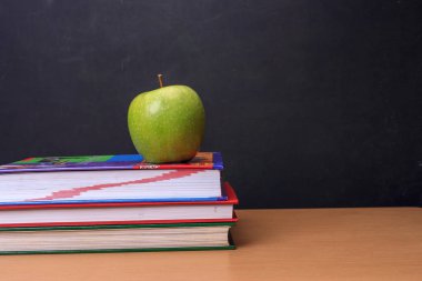 Apple, kitap ve bir yazı tahtası.