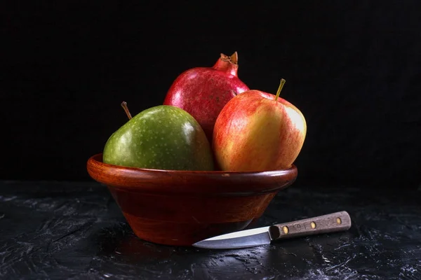 Knife next to bowl of fruit. — Stock Photo, Image