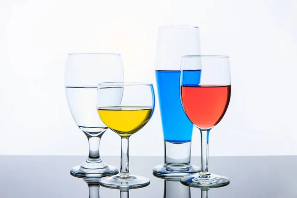 Bicchieri con acqua rossa, gialla e blu . — Foto Stock