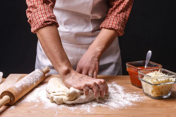 Vrouw indrukt en het deeg kneedt. — Stockfoto