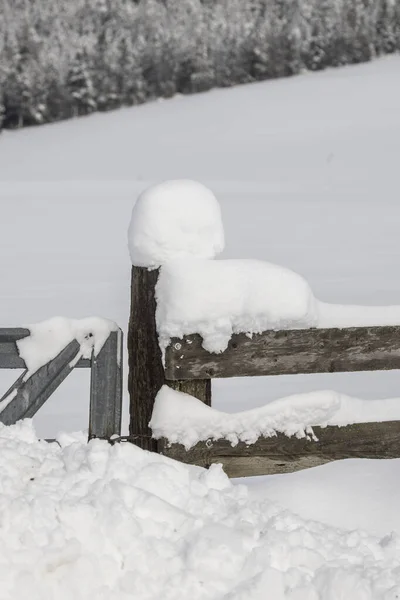 Snö täcker ett trästaket och stolpe. — Stockfoto