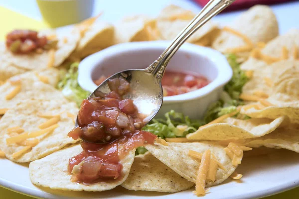 Putting salsa on a tortilla chip. — 스톡 사진