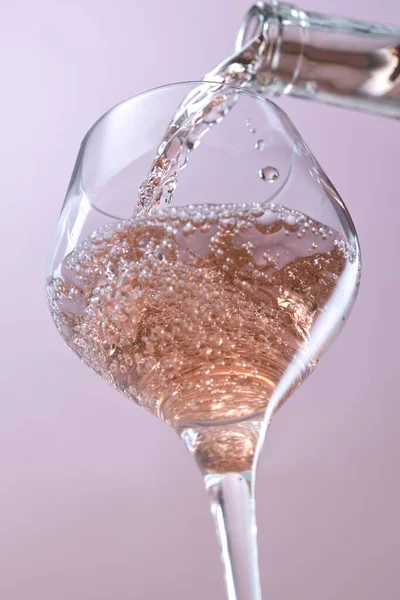 在杯子里倒酒的过程中 将玫瑰酒倒入酒杯的概念工作室形象 — 图库照片