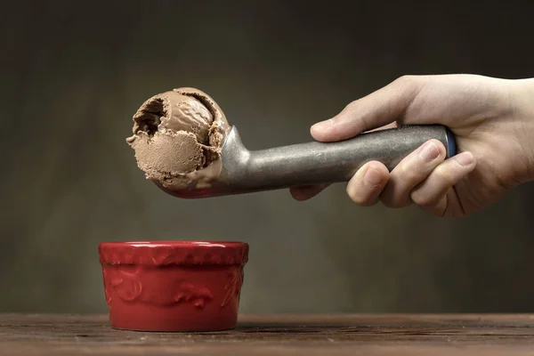 把巧克力冰淇淋放在碗里 一勺巧克力冰淇淋 装在金属冰淇淋里 放在碗上 — 图库照片