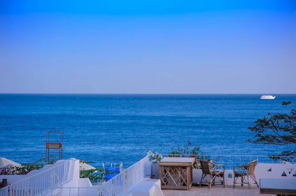 Table and chairs on the top red sea blue sky — Stock Photo, Image