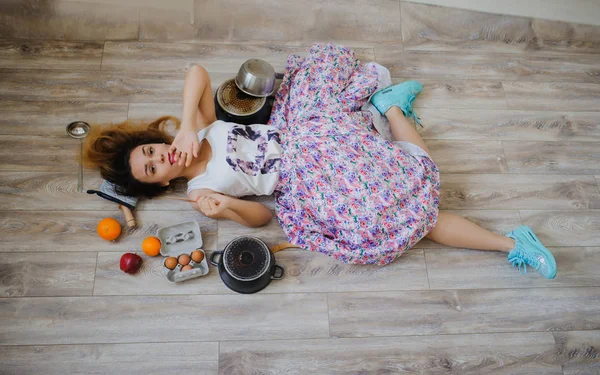 年轻女子躺在一个老式厨房的地板上 — 图库照片
