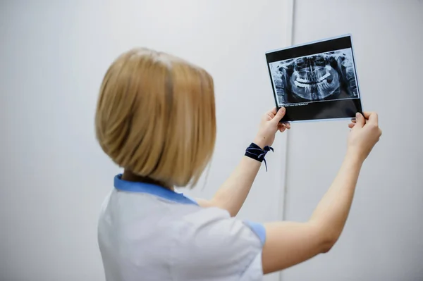 Dentist analyzes a dental panoramic x-ray film — Stock Photo, Image