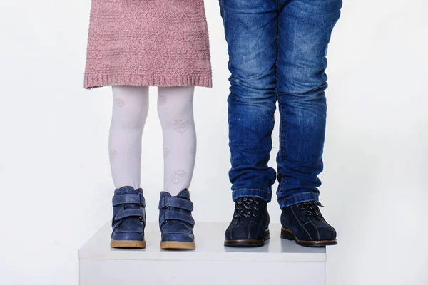 Детские ноги в обуви на белом фоне — стоковое фото