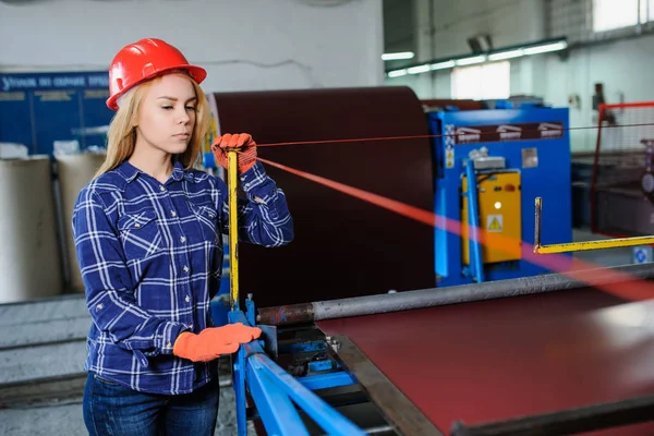 woman in red safety helmet at metal tile roof manufacturing fact