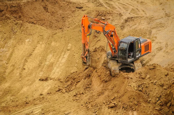 excavator moving earth and unloading into a dumper truck