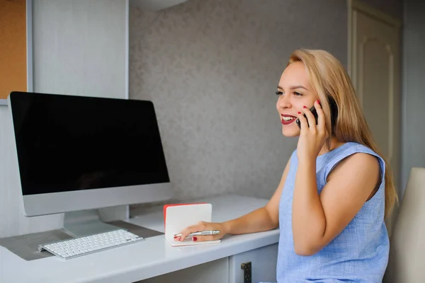 Felice giovane donna in abito blu che lavora su un pc — Foto Stock